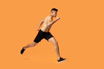 Fototapeta na wymiar A man in motion, running energetically on a vibrant orange background. His strides are powerful and determined, creating a sense of speed and urgency.