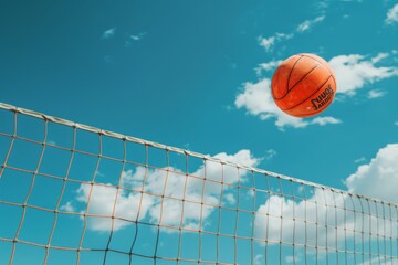 Volleyball in Mid-Air Over Net Against Clear Blue Sky