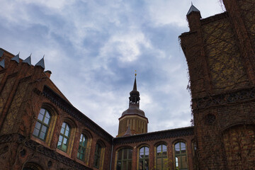 Obraz premium Blick vom Innenhof des Hansa-Gymnasiums auf den monumentalen Turm der St. Marienkirche, Backsteingotik am Neuen Markt, UNESCO-Welterbe, Hansestadt Stralsund, Vorpommern, Deutschland