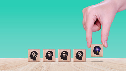 Thinking skills for business leader and manager concept. creative, systematic thinking skill, Hand business picked wooden cube block with head human symbol and light bulb icon creative idea concept.