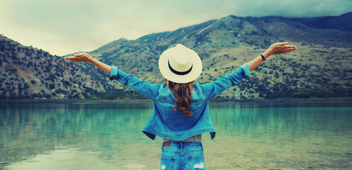 Summer vacation tourism, happy woman tourist on lake and mountains background