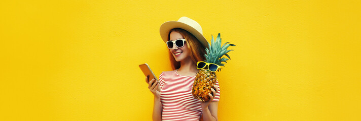 Summer portrait of traveler young woman with smartphone holding pineapple fruit
