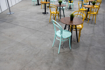 Colorful wooden chairs and tables in a public restaurant. Public places for eating quick meals.