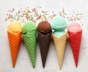 assorted ice cream of different flavors in waffle cones