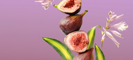 Pieces of fresh juicy figs with leaves and flowers decoration, falling on violet background.
