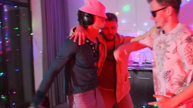 Happy funny young men friends have fun together dancing at home party. Nightlife music disco drinks celebration.