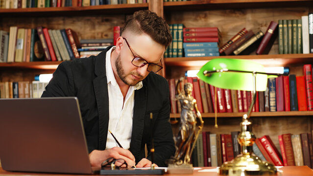 Justice and law concept. Lawyer works with laptop in court office. Concept of legal work, litigation.