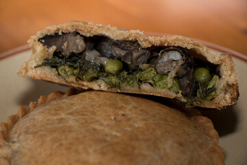 One and a half empanada, stuffed with vegetables and snails.