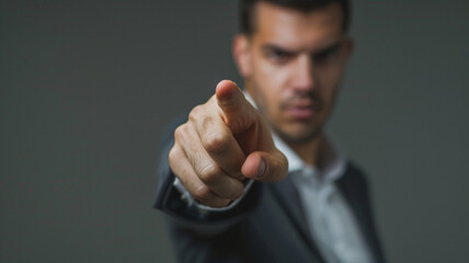 close up of businessman pointing finger on a grey background with copy space for your text