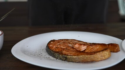 fried red fish on a plate, salt and pepper sprinkled