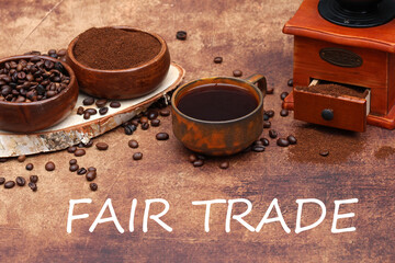 	Fair Trade Coffee: Arrangement with coffee cup, coffee grinder and roasted coffee beans with the...