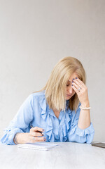 Tired woman touching forehead having headache migraine. Vertical shot