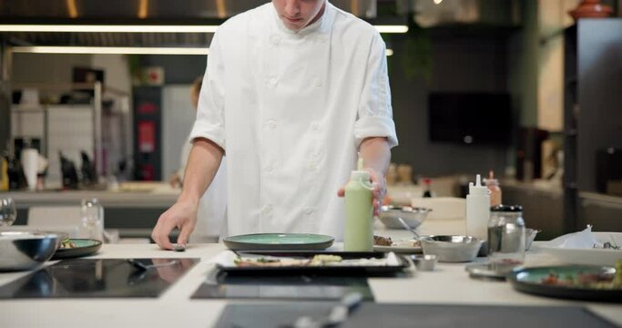 Man, chef and preparation plate or presentation for culinary food for fine dining cooking, professional or kitchen. Male person, sauce and bottle for customer service or hospitality, meal or gourmet