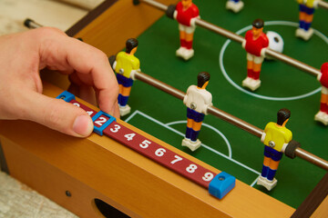 Hand moves the score on table football, score in football, table football game, close-up