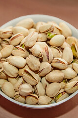 Plate with pistachios, pistachios on a plate, close-up, vertical shot