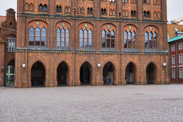 Naklejka premium Gotische Arkaden und Backsteinfassade des historischen Rathauses am Alten Markt in der Hansestadt Stralsund, Mecklenburg-Vorpommern, Deutschland