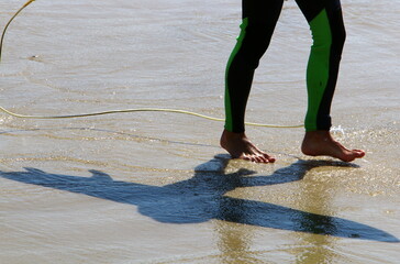 An athlete walks barefoot on the sand on the seashore.