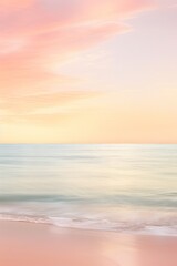 Fototapeta premium Pastel sunrise over calm ocean. The photo depicts a serene scene with soft pink and yellow hues in the sky reflecting. Vertical image with copy space.. soft foto