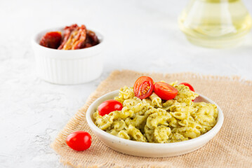 Italian pasta Creste Di Gallo with fresh cherry tomatoes and pesto sauce.