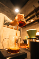 Professional Barista Prepares Fresh Cappuccino in a Busy Cafe: Closeup of Hands Skillfully Using Espresso Machine, Emphasizing the Art of Hot Beverage Making and Quality Service in a Cafeteria