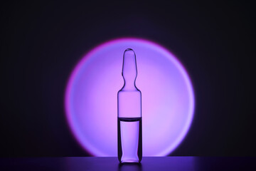Several ampoules for injection with medicines on a lilac background.