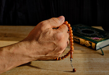 Hand of a senior Muslim man fingering a rosary