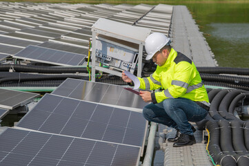 Engineer working at floating solar farm,checking and maintenance with solar batteries near solar panels,supervisor Check the system at the solar power station