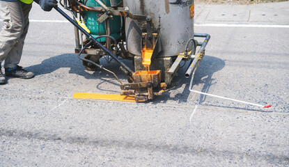 Man use thermoplastic road marking paint machine, hot melt marking paint machinery spraying a...