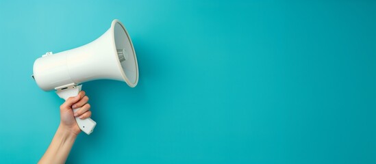 A woman's hand holds a white megaphone on a blue background. Concept of advertising, communication. Banner.