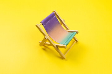 Colorful beach chair on yellow background. Summer, holidays and beach concept. Creative...