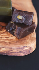 Traditional Japanese yokan jelly cake, adzuki red bean, chestnut and matcha green tea flavoured, on wood board on black background