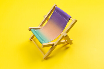 Colorful beach chair on yellow background. Summer, holidays and beach concept. Creative...