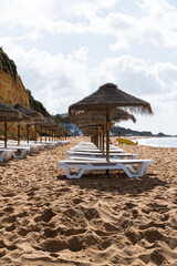 Straw chairs and umbrella. Praia do Peneco beach, Albufeira, Algarve, Portugal. Praia dos Pescadores beach. Fishermen, sunny day