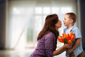 Mother's day concept. Child congratulating mother giving bouquet of flowers.