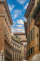 A view from inside on of the streets of Verona - Italy looking up at the sky with the facades of the buildings 