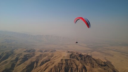 Paraglider Soaring Over Mountain Range