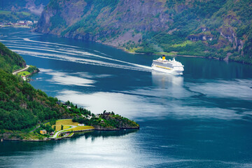 A large cruise liner navigates the waters of Sunnylvsfjorden fjord near the village of Geiranger in...