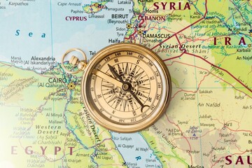 Magnetic old retro compass at world map.