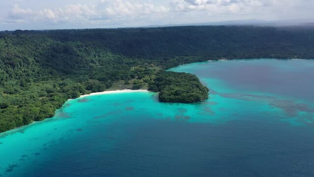 Drone video of green shore near turquoise sea under blue clouds. Tropical paradise. Sanma, Vanuatu.