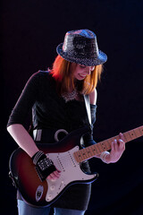 Obraz premium Woman smiles while playing electric guitar confidently