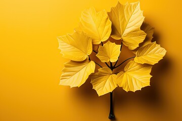 A yellow leaf on a brown twig on a yellow background.