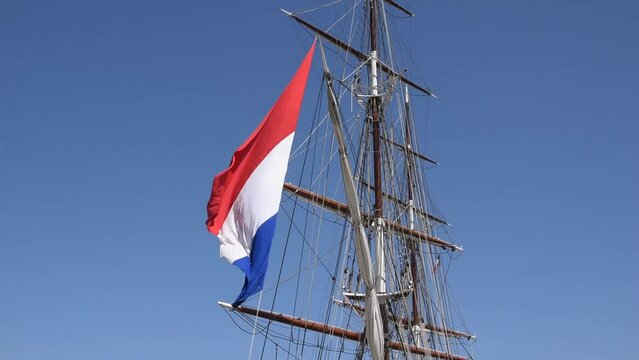 A mast of the brig and flag of France swinging in the wind
