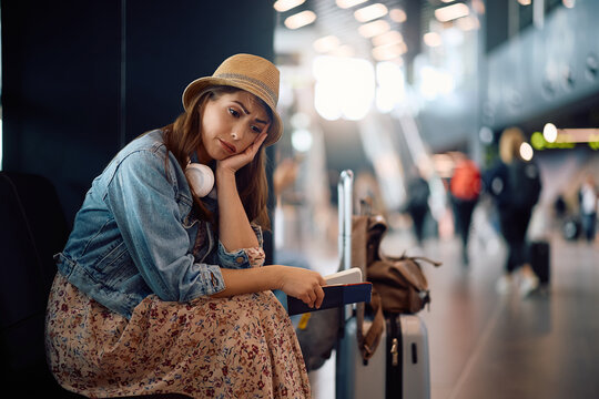 Young traveler feeling distraught about her delayed flight at airport. Copy space.