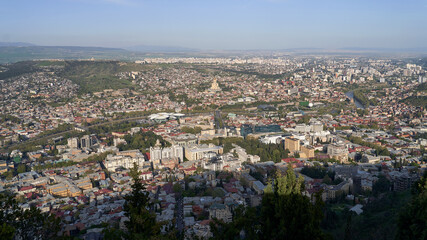 Fototapeta na wymiar Wide angle view of beautiful city if Tbilisi and Kura river from Mount Mtatsminda with Holy Trinity Cathedral in the center and Old Town on the right side