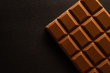 Overhead shot of a rectangular piece of chocolate on a black background