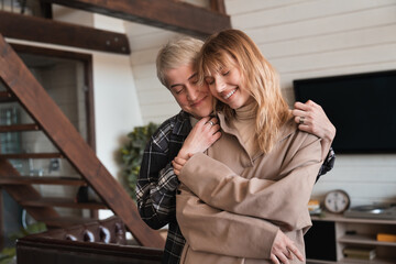 Making surprise. Showing care. Two best friends girlfriends LGBT couple lovers lesbians hugging embracing indoors, spending time together expressing their passion and love.