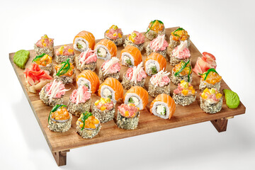 Delicious set of sushi rolls with various toppings on wooden tray
