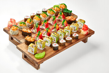 Set of assorted Japanese sushi rolls and gunkan maki on wooden tray