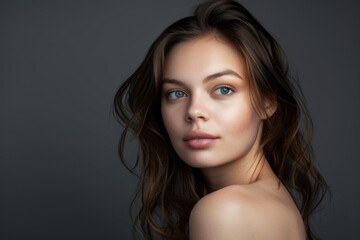 Naklejka premium Portrait of an attractive woman on a gray background. Female beauty.