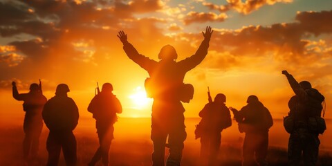 Group of people with arms raised in a sign of victory or celebration at sunset